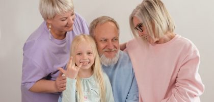 A joyful multigenerational family poses and smiles together indoors, showcasing love and togetherness.